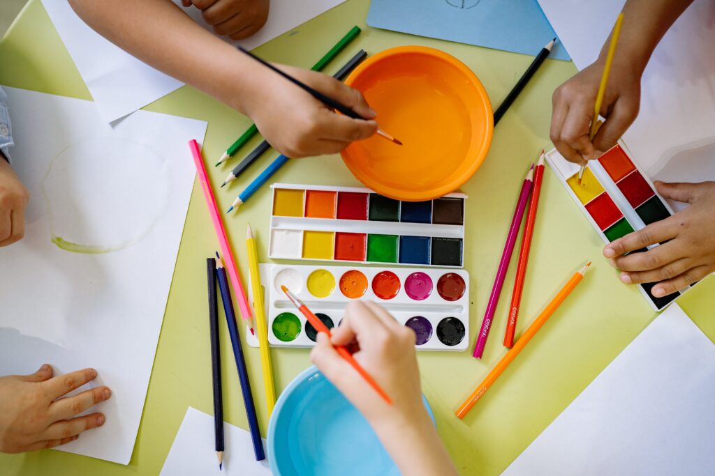 children playing with paints and color pencils
