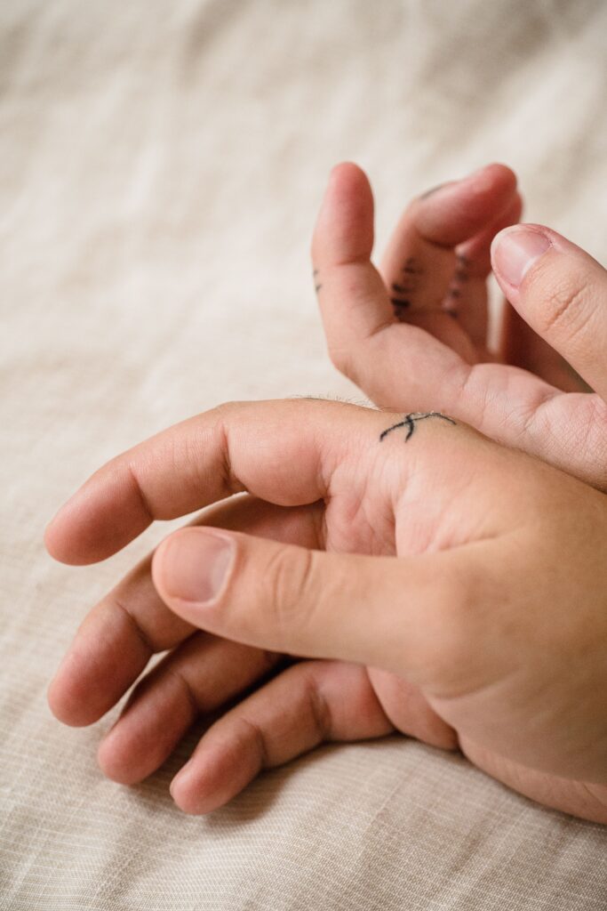 close up of tattooed hands touching